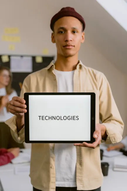 A young man holding a tablet displaying the word '